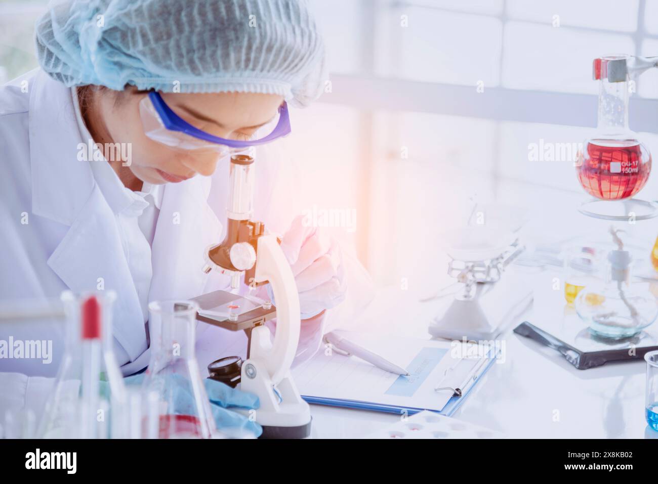 Female scientist look at microscope, science test tube analyse scientific sample in laboratory research experiment biotech make cultivate vaccine agai Stock Photo