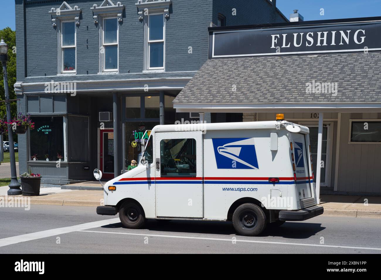 US Postal Service Grumman mail delivery van in downtown Flushing Michigan USA Stock Photo