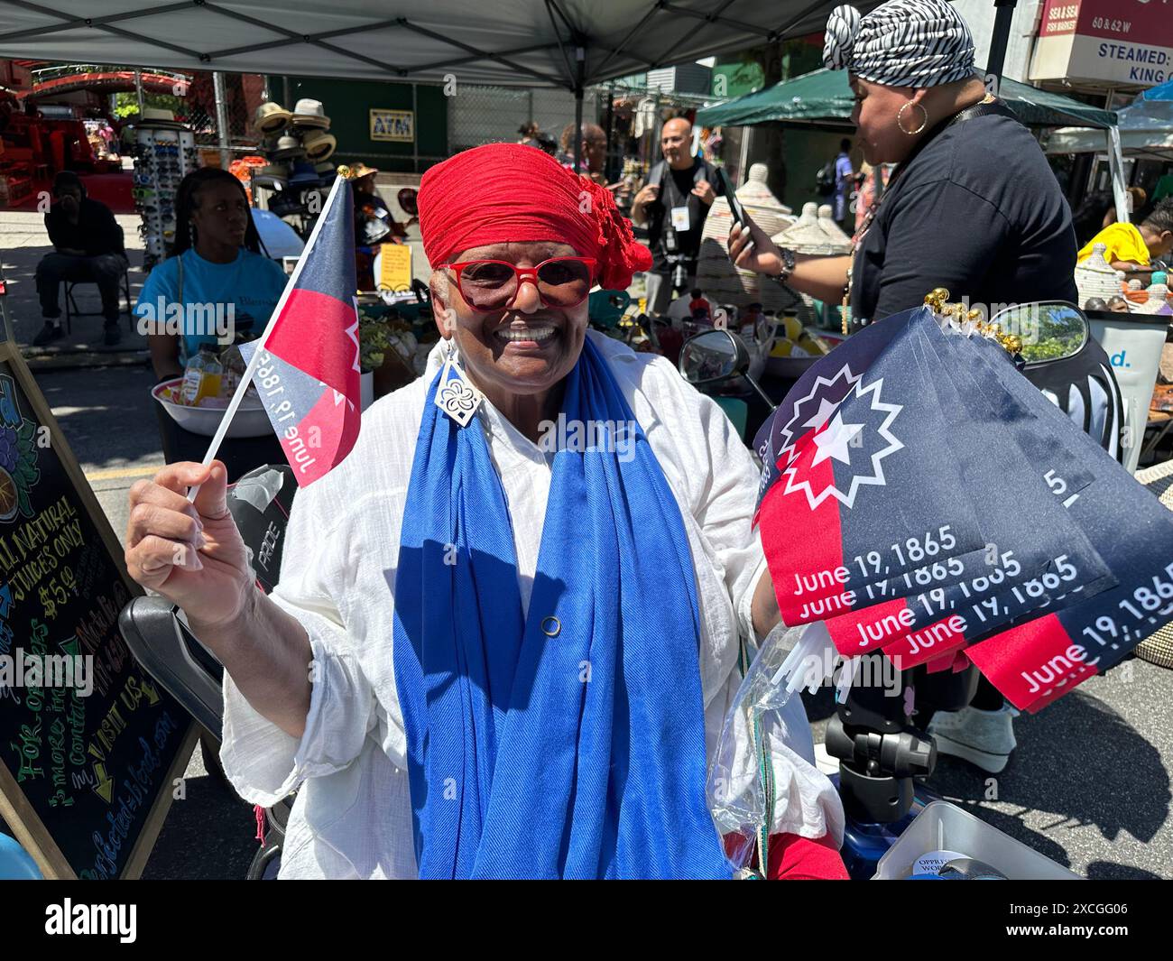 New York, N.Y. - June 15, 2024: Vendor selling flags at the 31st annual Harlem Juneteenth Celebration Parade and street festival which is organized by Masjid Malcom Shabazz. Juneteenth is a federal holiday commerating the end of slavery in the United States on June 19, 1865, when Major General Gordon Granger ordered the final enforcement of the Emancipation Proclamation in Texas at the end of the American Civil War. Stock Photo