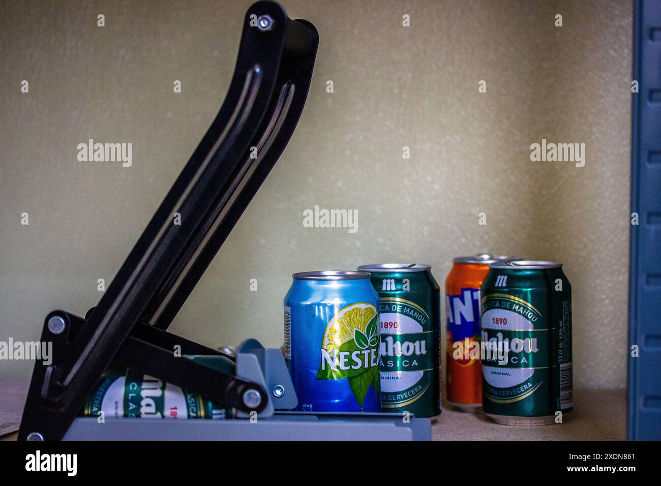 Madrid, Spain. May 1, 2024 Crusher, press, shredder for aluminum cans from water, sourdough, beer. Mahou beer, Nestie drink, Fanta. Plastic recycling. Stock Photo