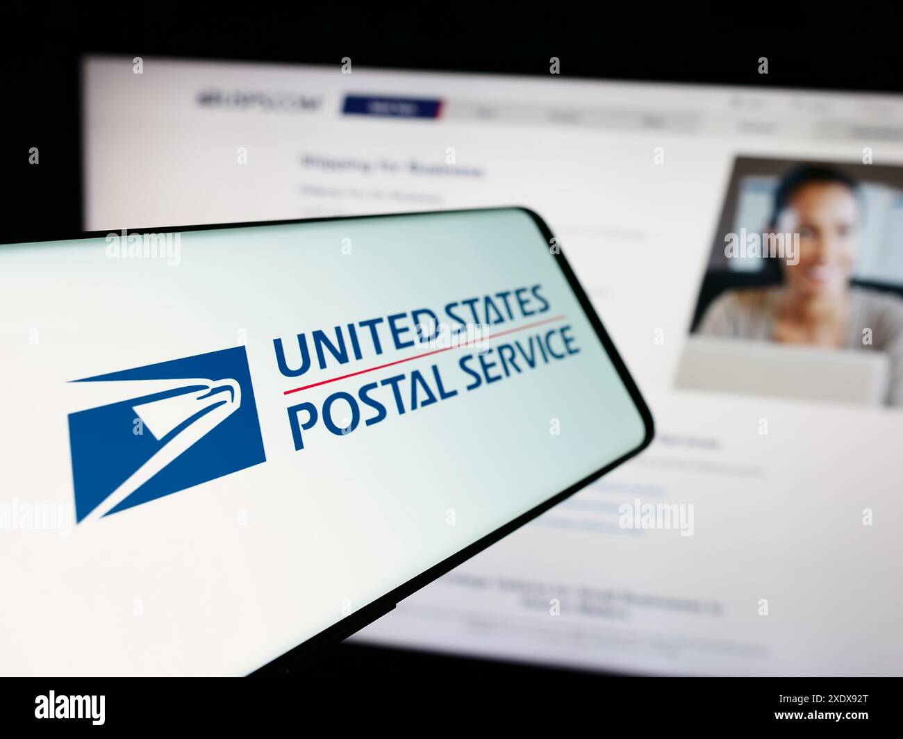 Cellphone with logo of American agency United States Postal Service (USPS) in front of website. Focus on left of phone display. Stock Photo