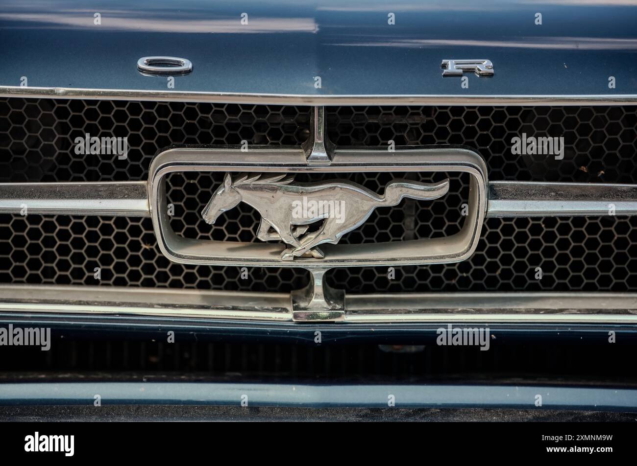 Pony car, bonnet grill of a classic Ford Mustang muscle car with chrome logo. Ropley Hampsire, UK Stock Photo