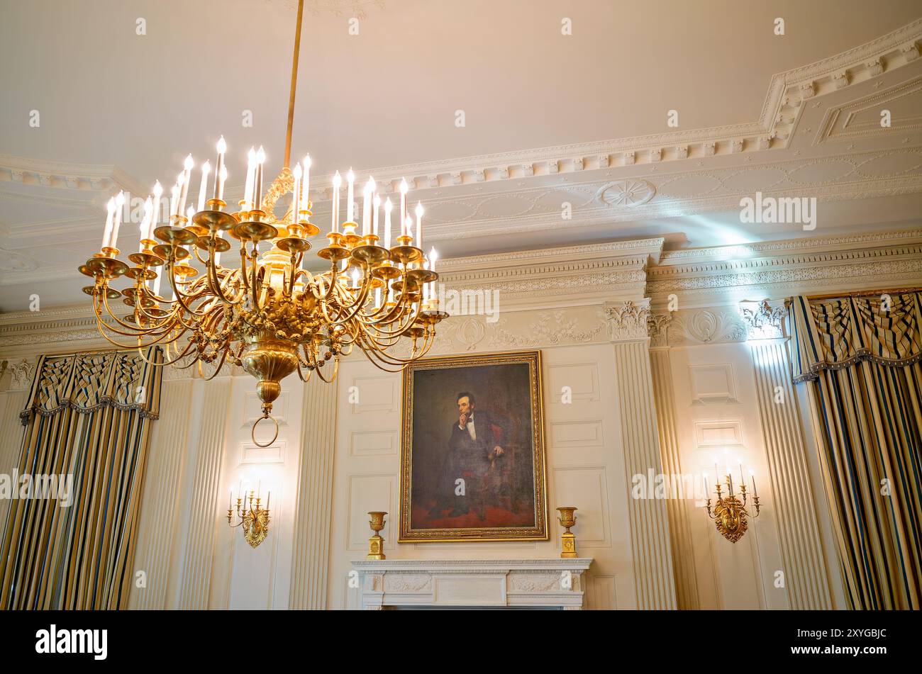 WASHINGTON DC, United States — The State Dining Room in the White House, featuring the iconic portrait of Abraham Lincoln by George P.A. Healy. This grand room, used for official state dinners and receptions, showcases elegant decor including a large fireplace beneath the Lincoln painting. The room's design reflects the rich history and significance of presidential entertaining in American diplomacy. Stock Photo