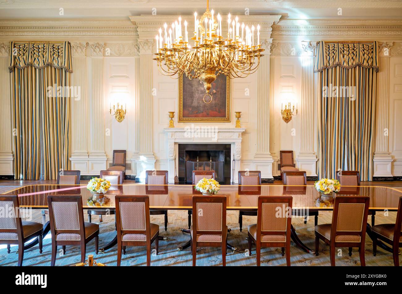 WASHINGTON DC, United States — The State Dining Room in the White House, a grand space used for official state dinners and diplomatic receptions. This historic room features elegant decor, including a large fireplace and a prominent portrait of Abraham Lincoln. The State Dining Room can accommodate up to 140 guests for formal seated dinners. Stock Photo