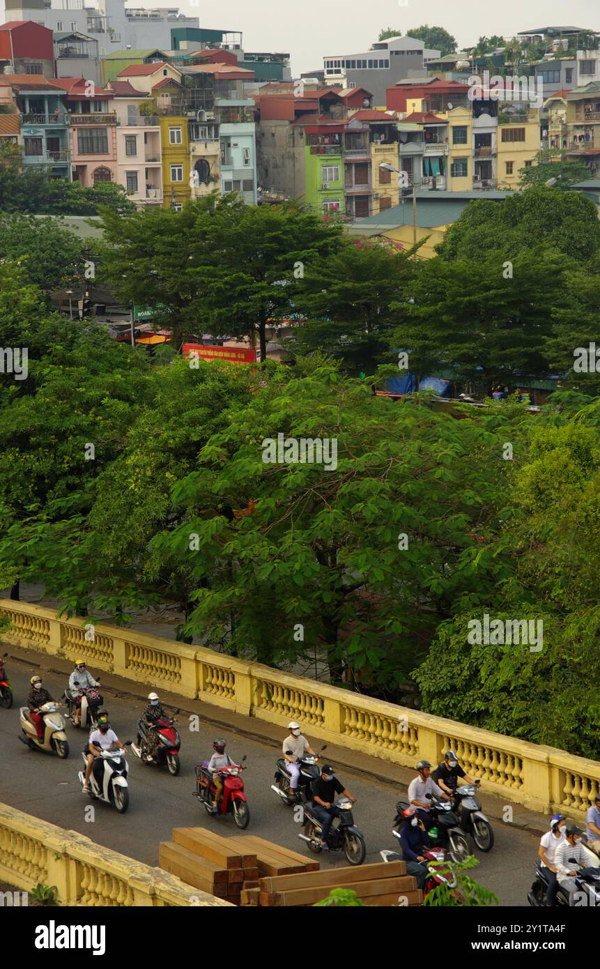 Traffic in Hanoi with a backdrop of colorful buildings. Stock Photo