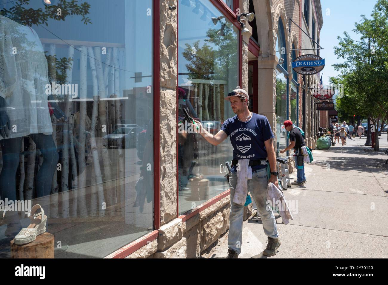 Steamboat Springs, Colorado - Men wash windows at downtown stores. Stock Photo