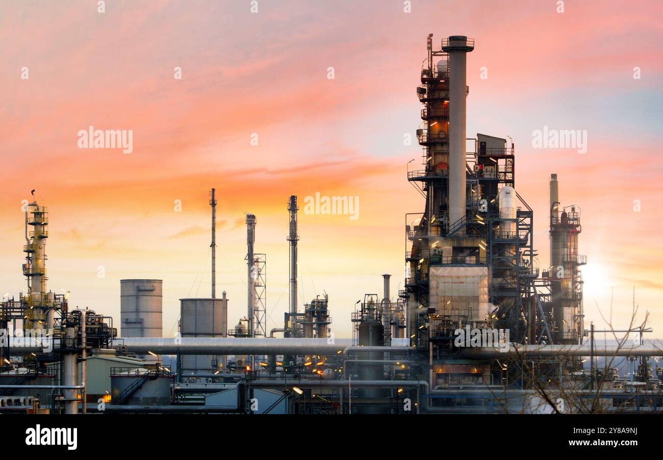 Oil refinery and plant and tower column of Petrochemistry industry in oil and gas industrial with cloud orange sky the sunrise background Stock Photo