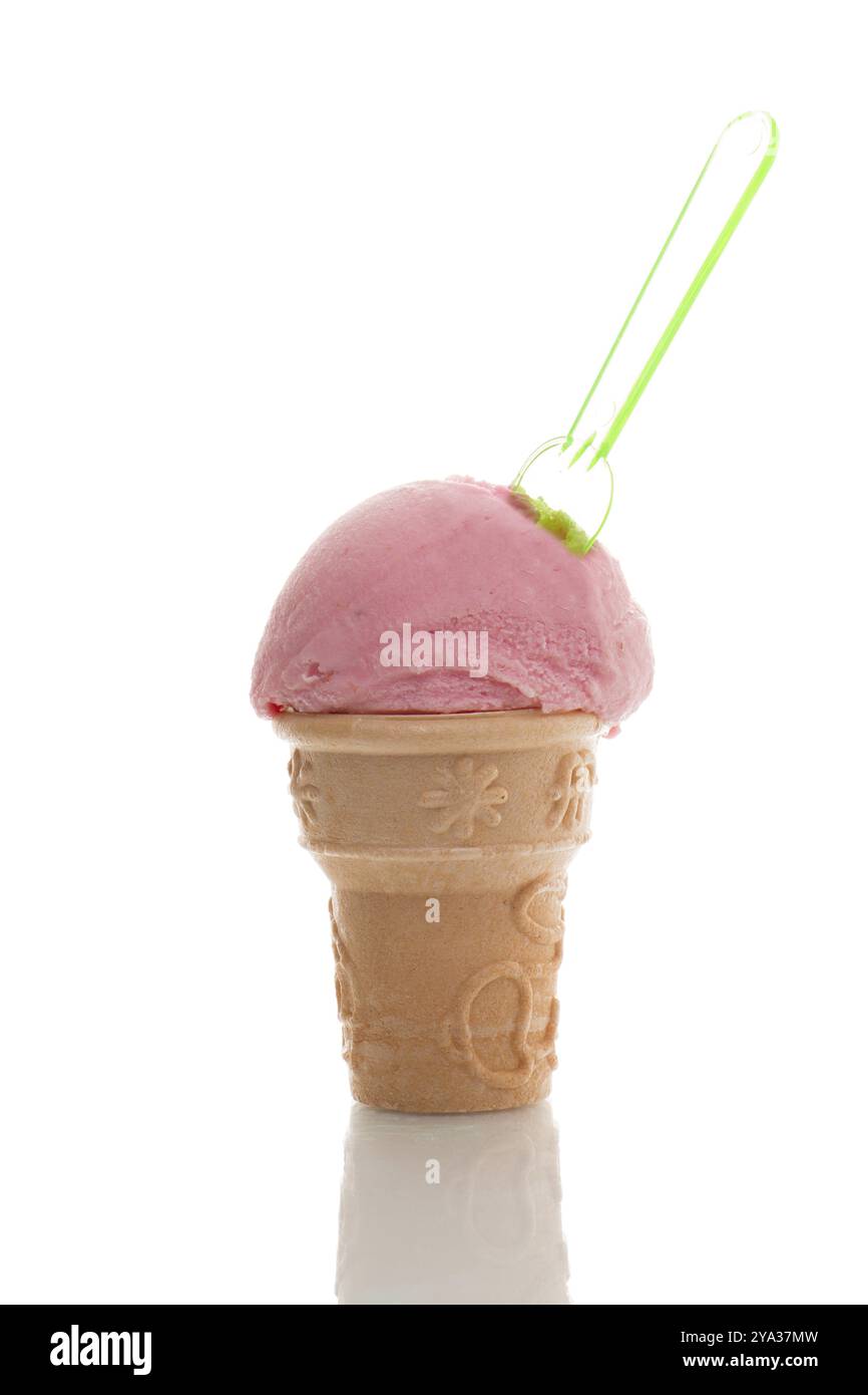 A scoop of strawberry ice cream in a cone with a spoon Stock Photo