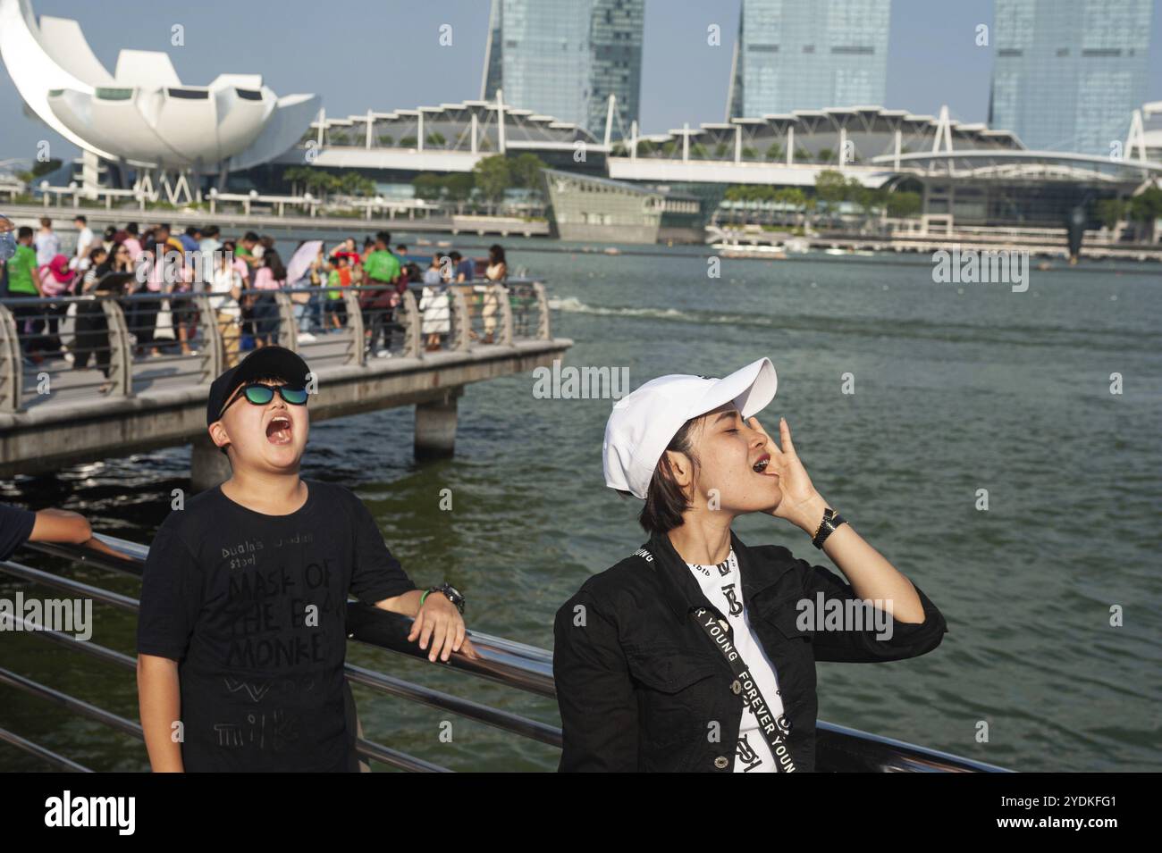 01.08.2019, Singapore, Republic of Singapore, Asia, Tourists pose for photos in Merlion Park on the banks of the Singapore River with the Marina Bay S Stock Photo