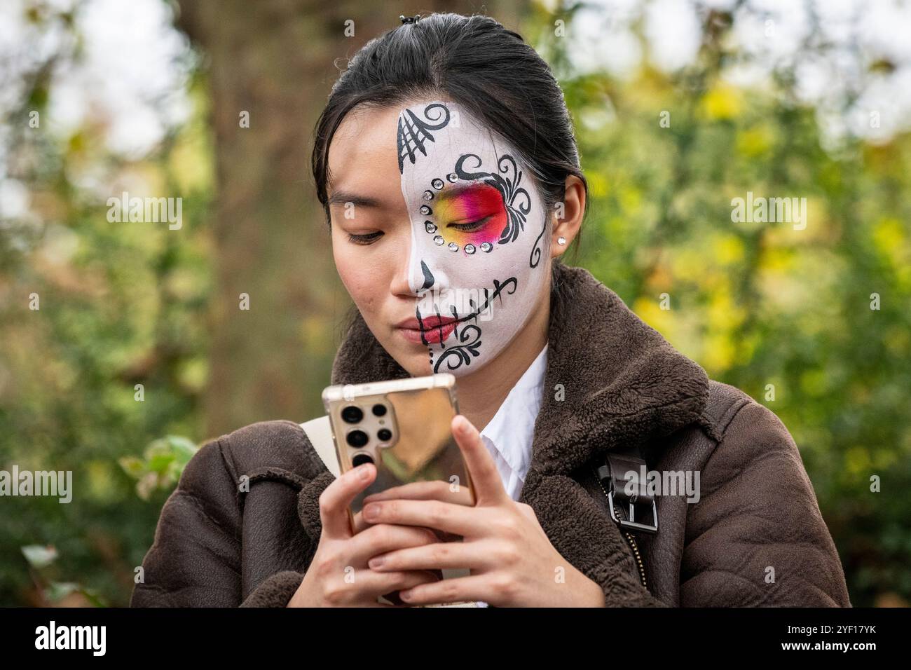 London, UK.  2 November 2024. A reveller in facepaint celebrates the Mexican Day of the Dead on Columbia Road in East London.  The Mexican Day of the Dead is, despite its name, a joyful celebration honouring the passing of loved ones, where the spirits of the ancestors return and coincides with the Christian Festival of All Hallows’ Eve.  Credit: Stephen Chung / Alamy Live News Stock Photo