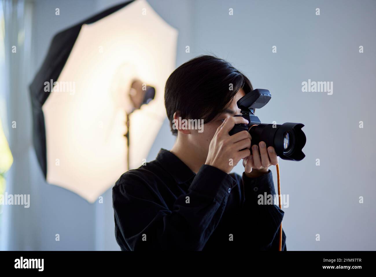 Japanese male photographer taking photographs at a photography studio Stock Photo