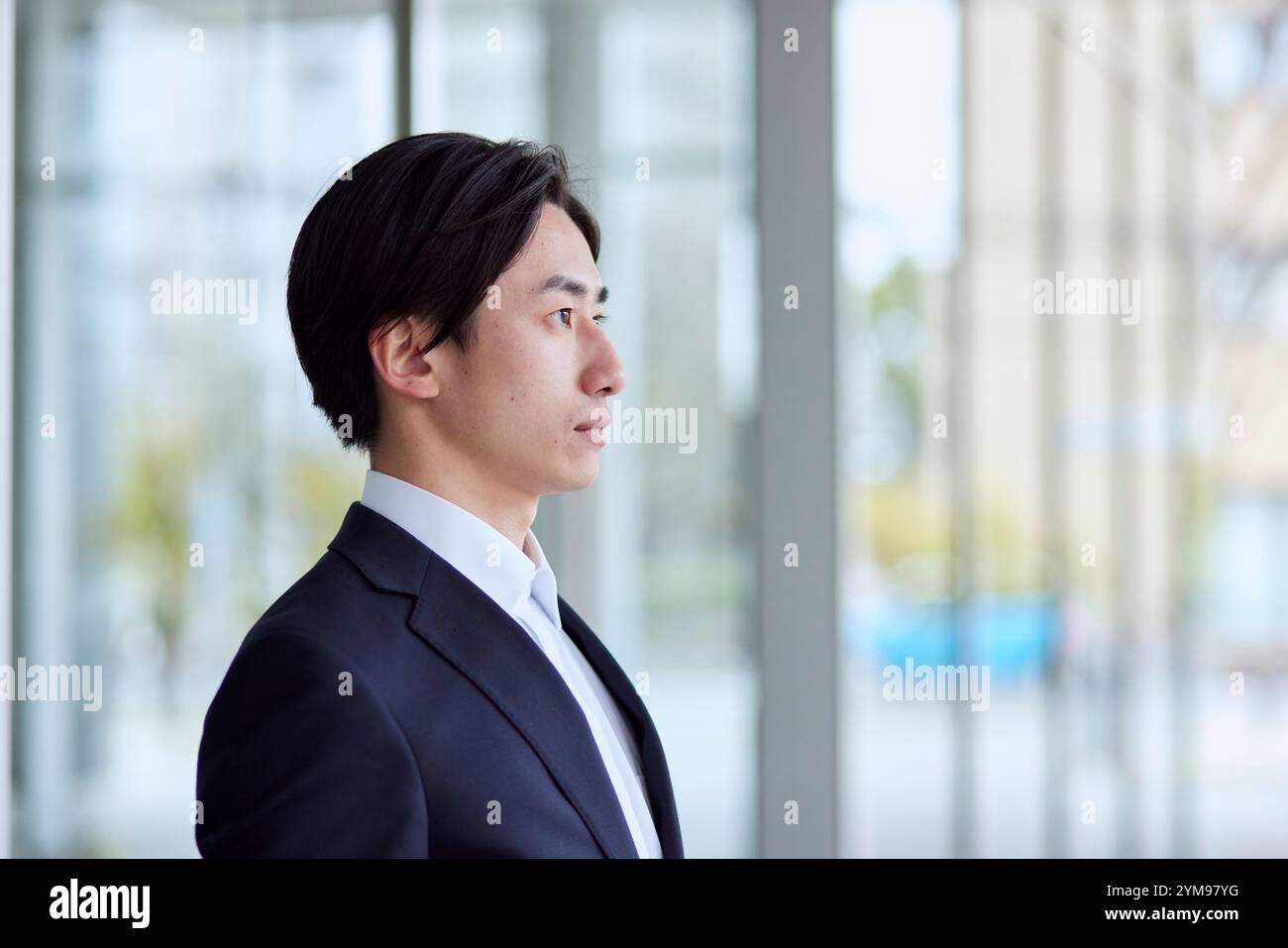 Office building and young Japanese businessman in suit Stock Photo