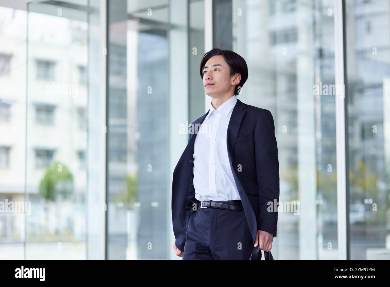 Office building and young Japanese businessman in suit Stock Photo