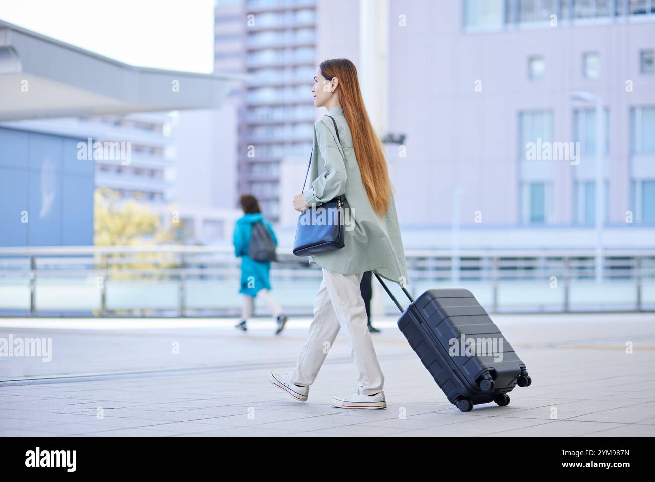 Female inbound international traveller moving with a suitcase Stock Photo