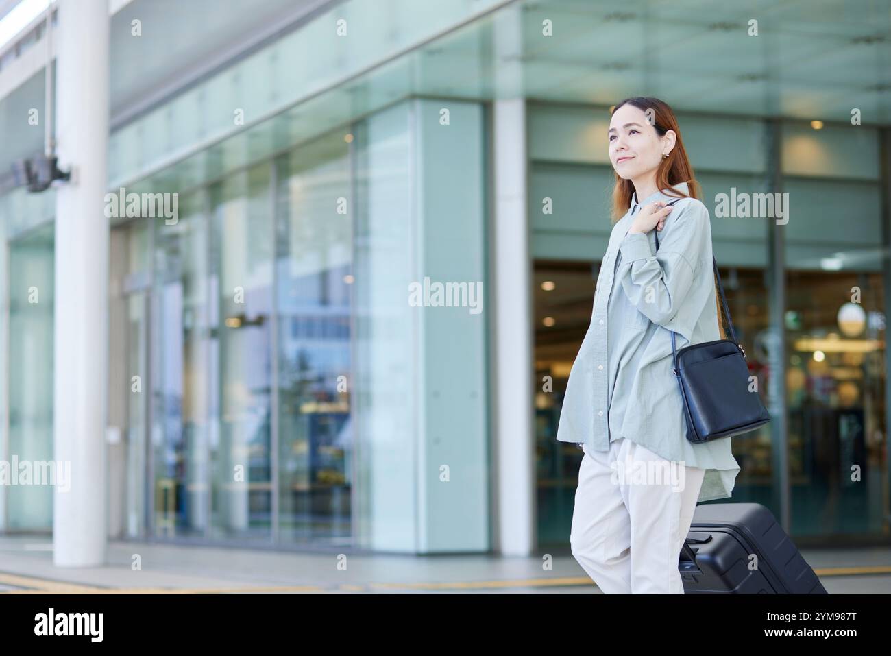 Female inbound international traveller moving with a suitcase Stock Photo