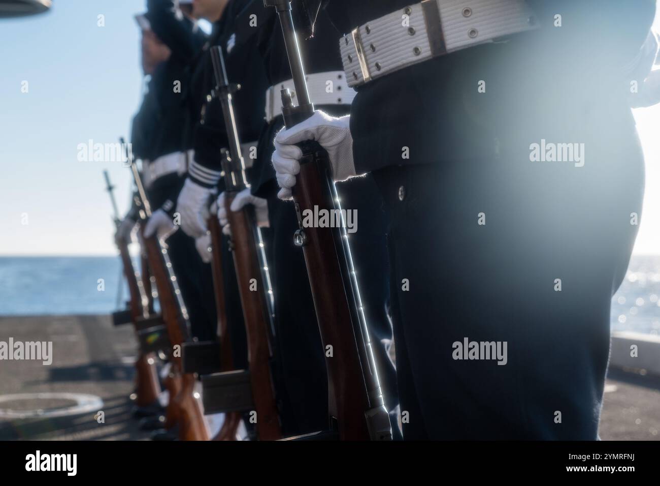 241120-N-TY704-1029 PACIFIC OCEAN (Nov. 20, 2024) Sailors assigned to the Nimitz-class aircraft carrier USS Carl Vinson (CVN 70) honor guard stand at parade rest during a burial-at-sea on the aircraft elevator aboard the ship. USS Carl Vinson (CVN 70), flagship of Carrier Strike Group ONE, is underway conducting routine operations in the U.S. 3rd Fleet area of operations. (U.S. Navy photo by Mass Communication Specialist 2nd Class Emily Claire Bennett) Stock Photo