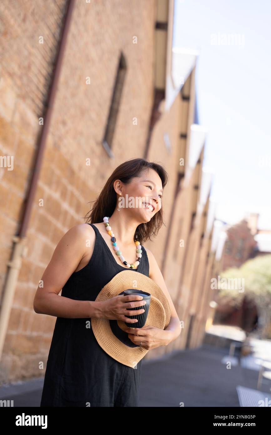 Woman walking around town with coffee in hand Stock Photo