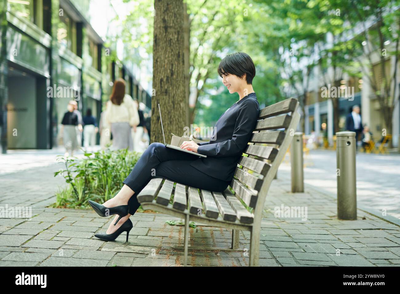 Female office worker in her 30s checking her work on a bench Stock Photo