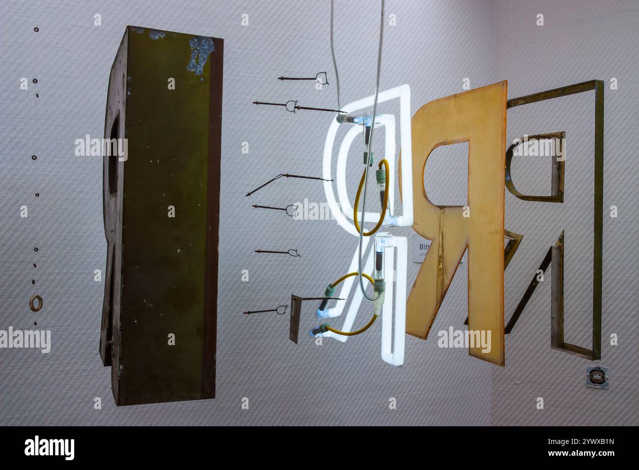 An exploded view of an advertising letter R with insight into what the neon sign letter is made of, an aluminum box with glass hooks for the neon and Stock Photo