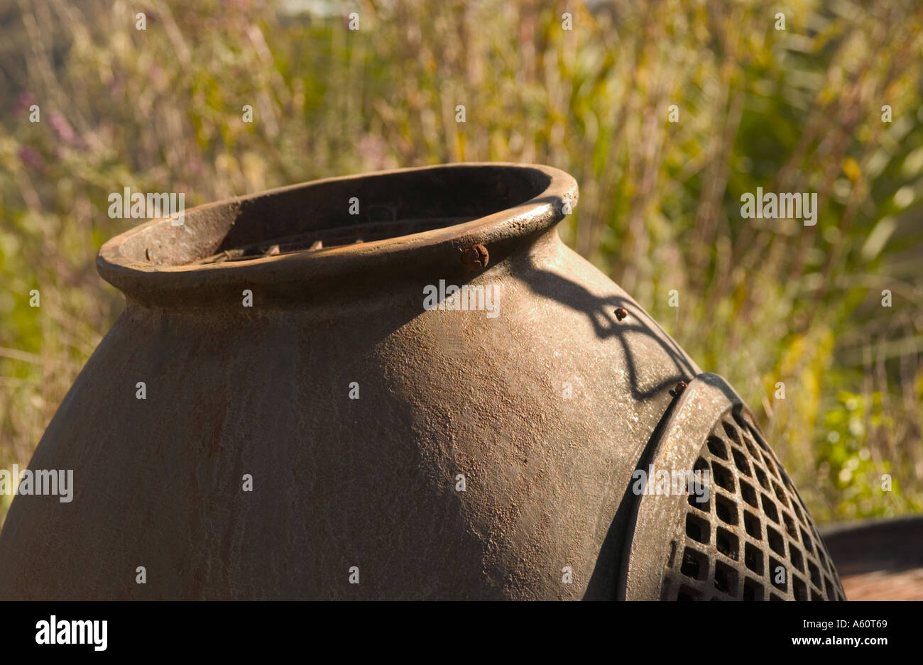 Old, rusty, cast iron potbelly stove in backyard patio. Stock Photo