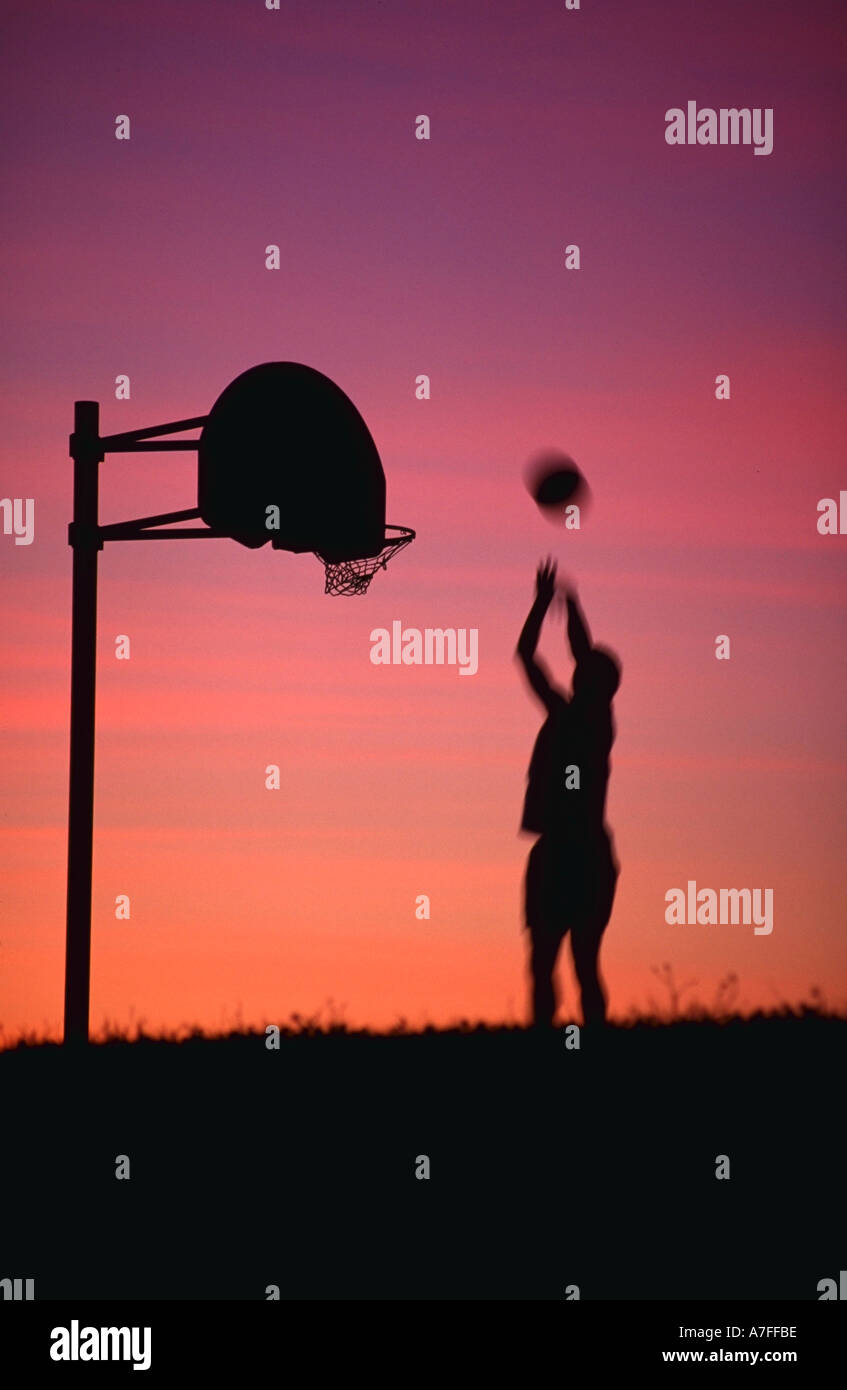 Silhouette of person playing basketball Stock Photo