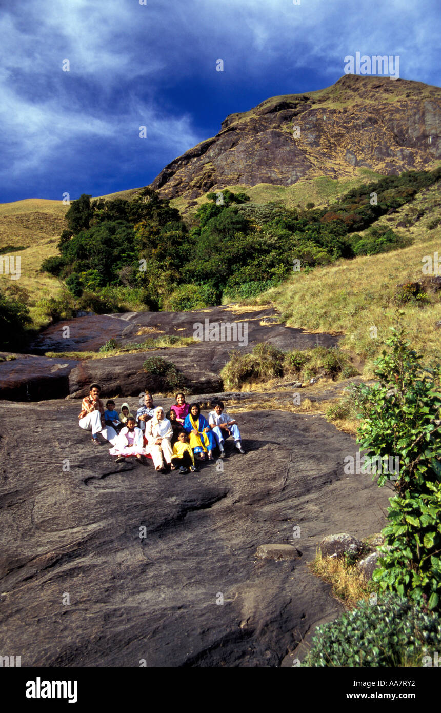 Indian tourists seated on Anamudi Mountain (2695m), peninsula India's highest peak, Kerala, South India Stock Photo