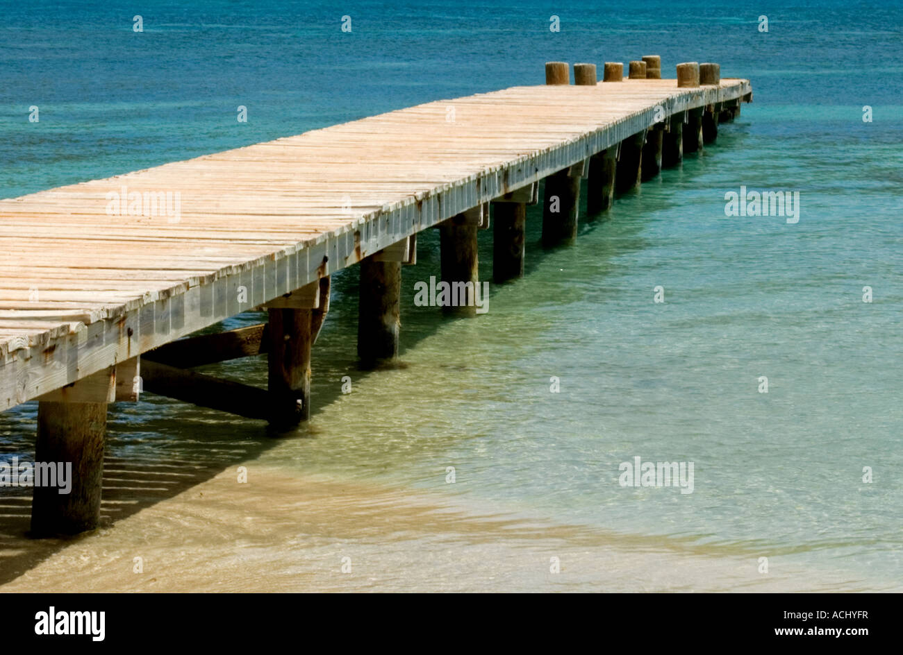 Wooden Jetty Pier over the Blue Ocean Sea in Antigua, Eastern Carribean Stock Photo