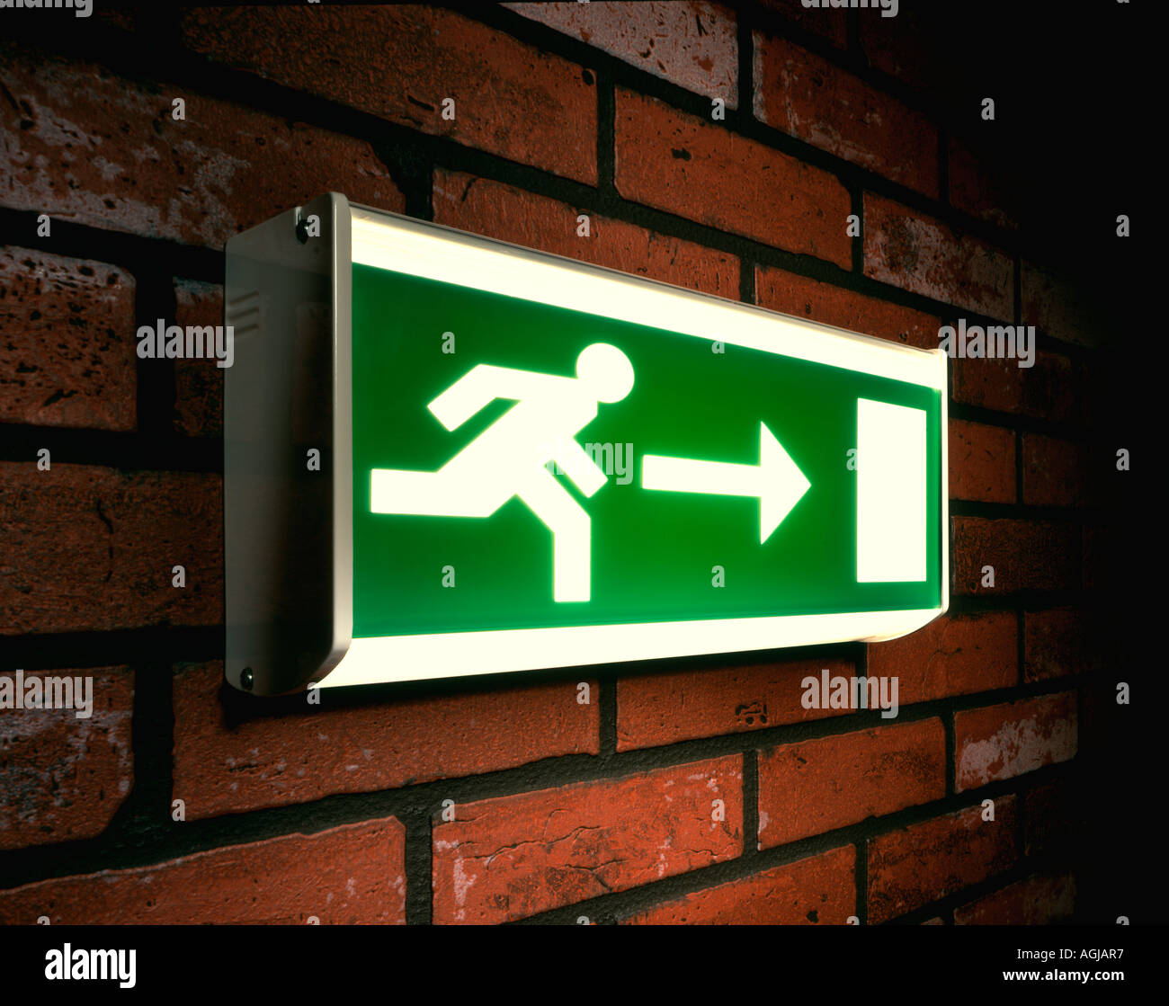 Running Man Emergency Exit sign on a brick wall Stock Photo