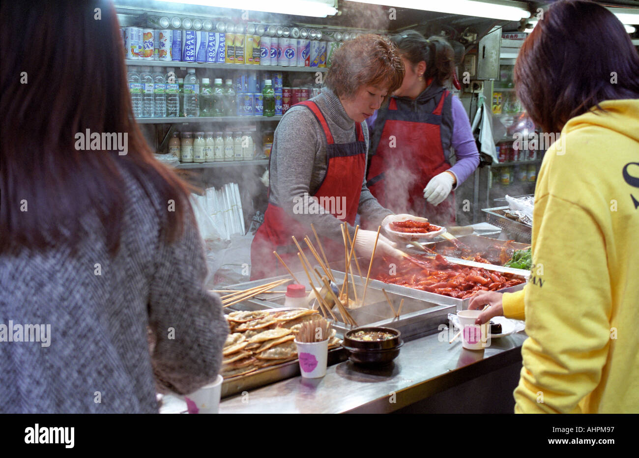 selling and buying food at a stall along Myungdung Street Mall in Seoul city Korea Asia Stock Photo