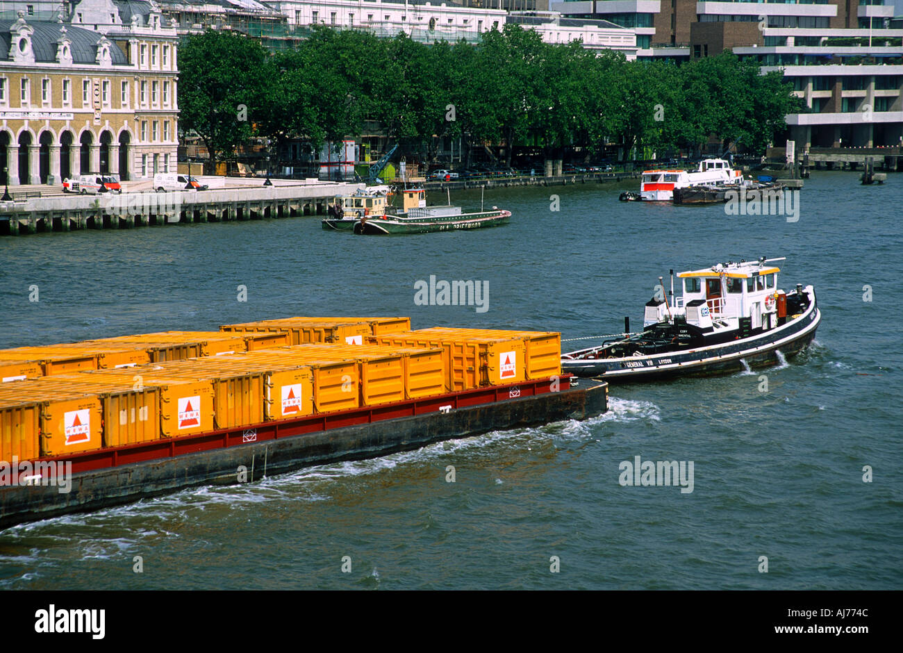 Tug towing barges loaded with containers River Thames London England Stock Photo