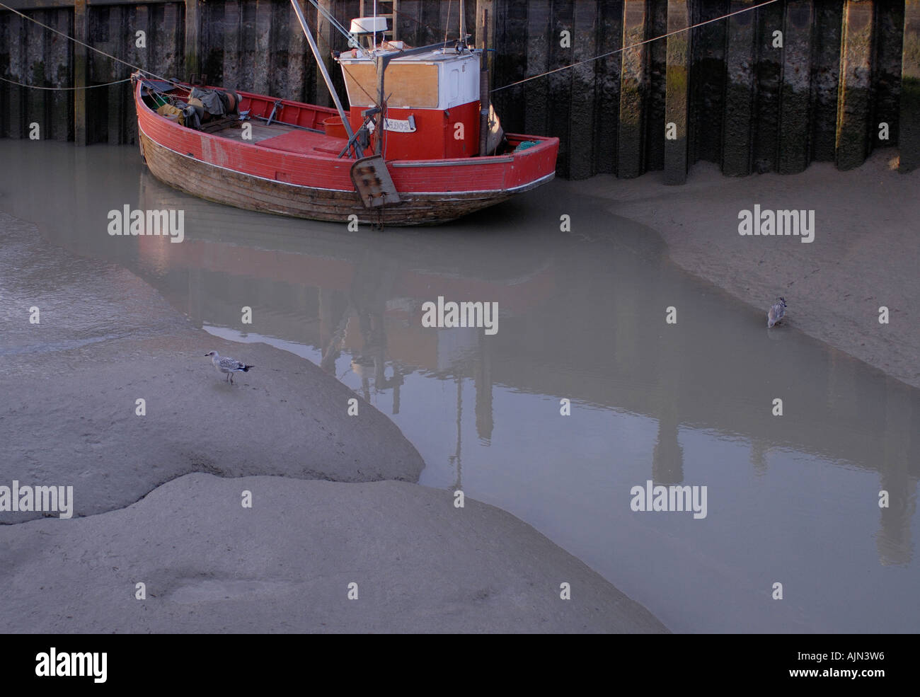 Red old fashioned traditional clinker built timber fishing boat Stock Photo