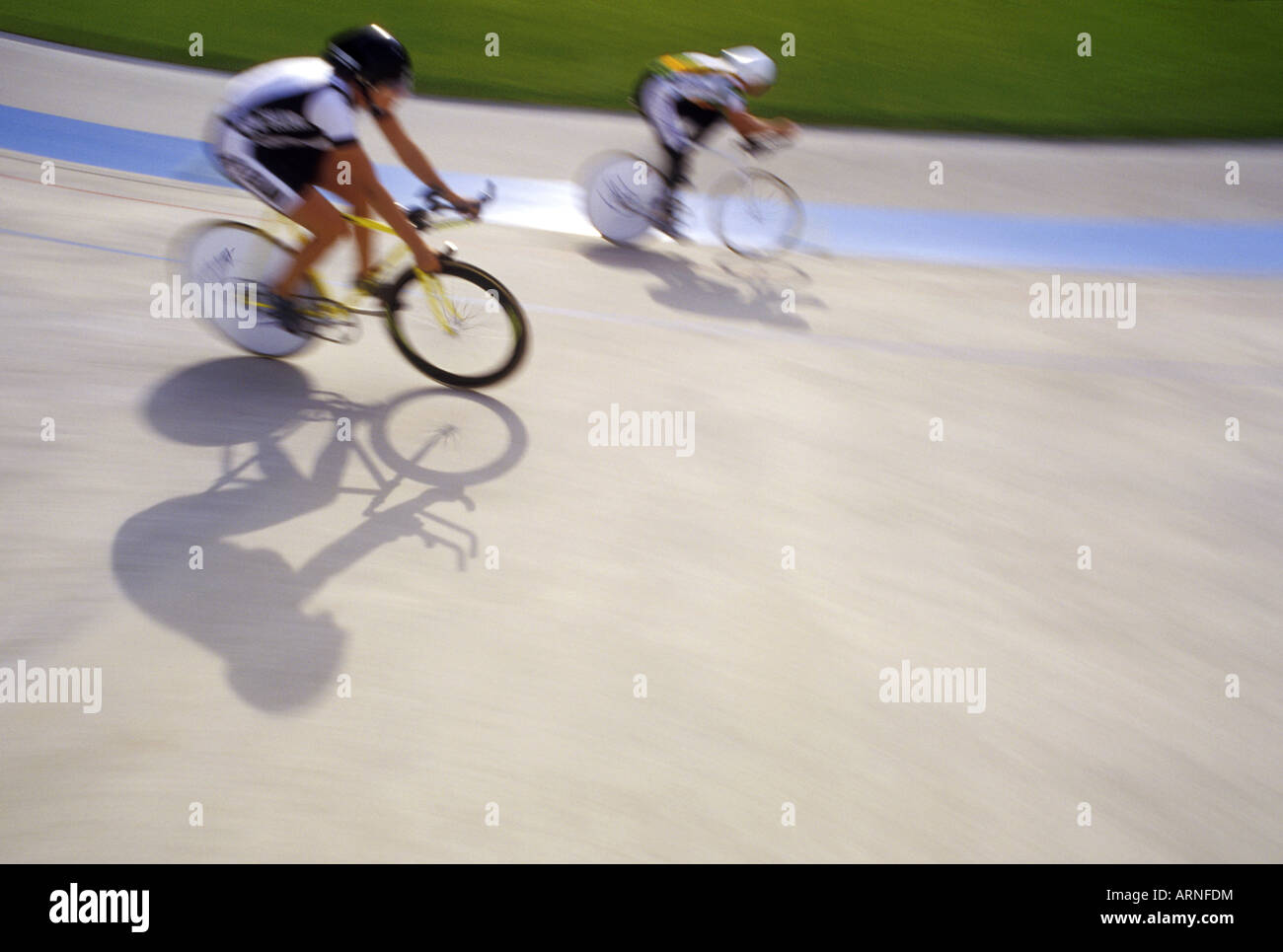 Bicycle racers on velodrome track with graphic shadows, British Columbia, Canada. Stock Photo