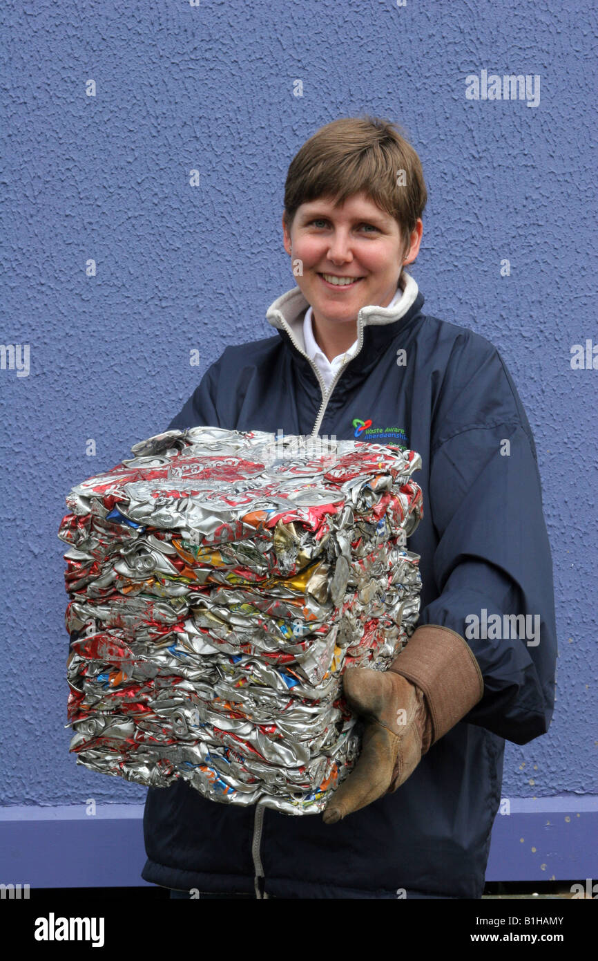 Council employee holding recycled trash, refuse, crushed, metal, garbage,  beverage Aluminium cans crushed into a cube in Blairgowrie, Scotland, UK Stock Photo