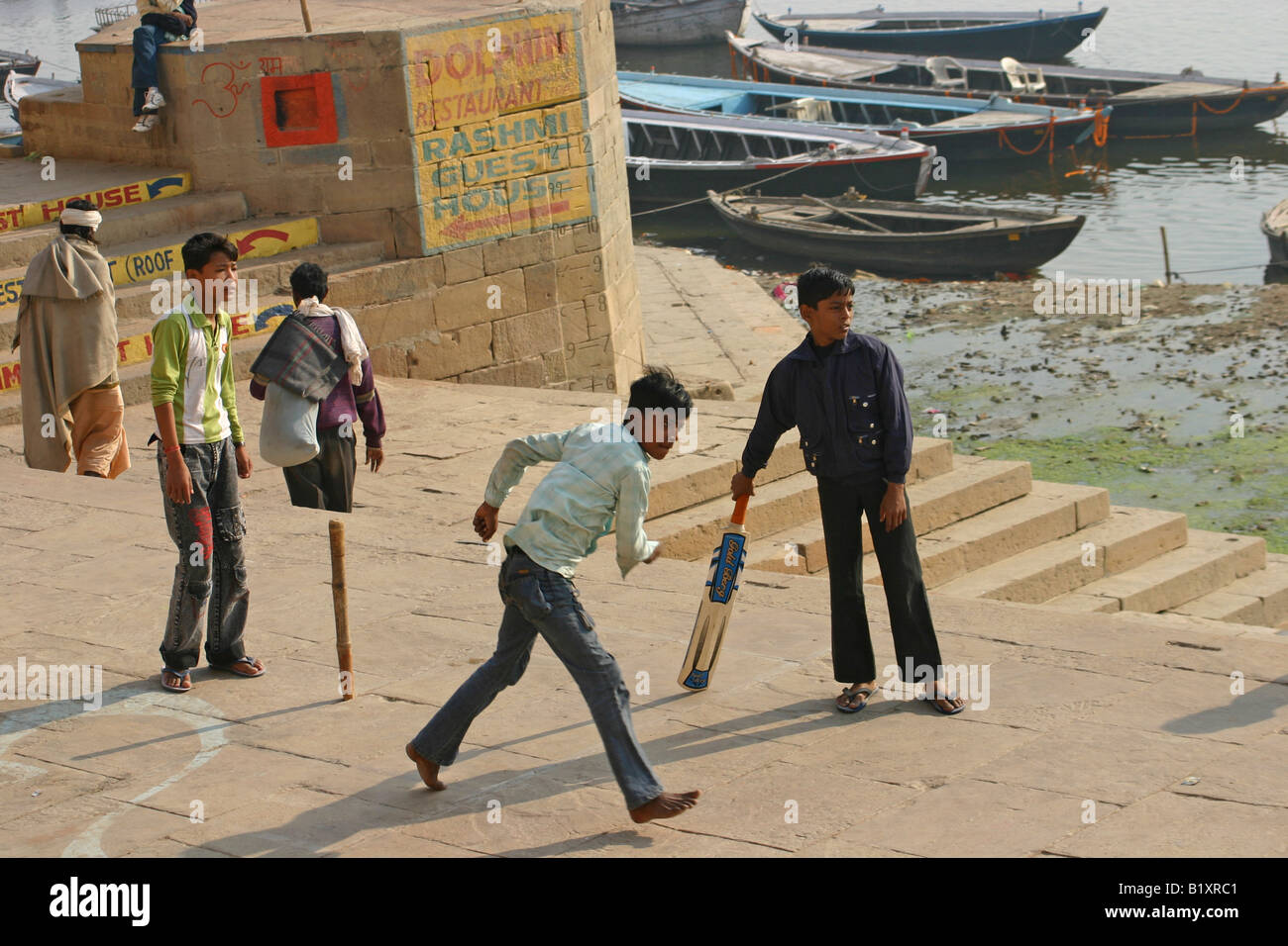 Boys playing cricket on the banks of the river Ganges, Varanasi Stock Photo