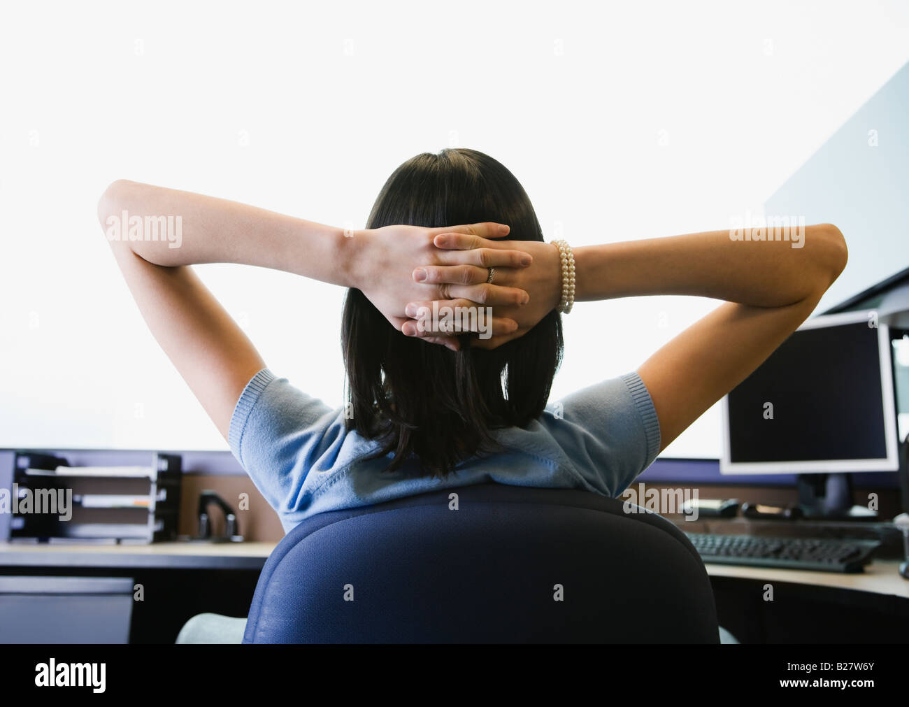 Businesswoman with hands behind head Stock Photo