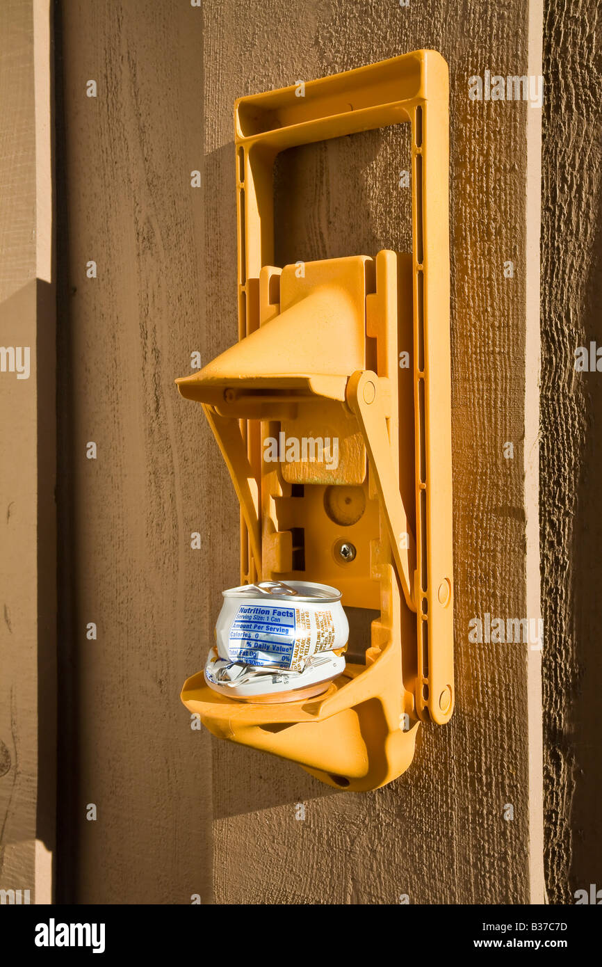 Inexpensive aluminum can crusher mounted on wall. Stock Photo