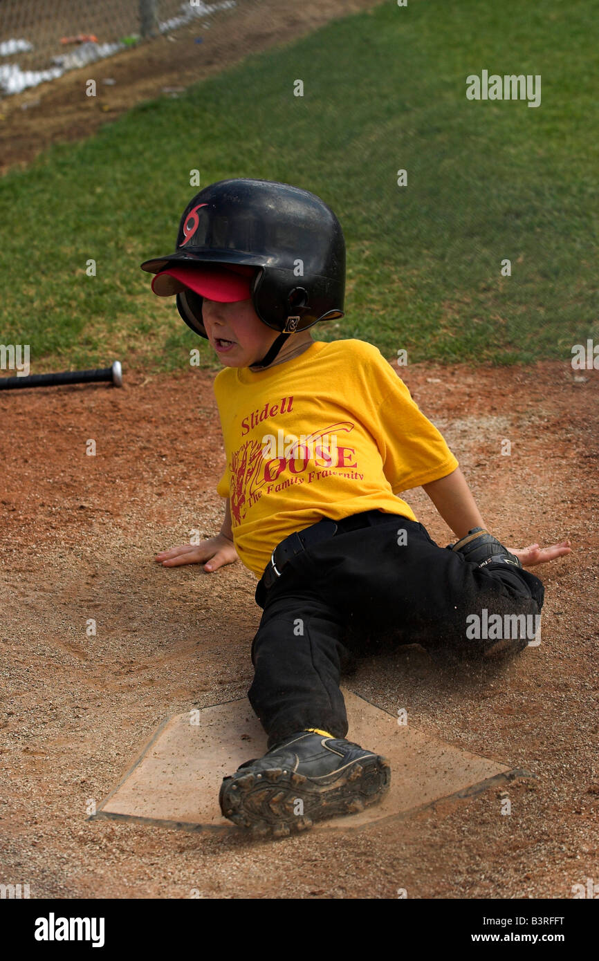 A little league baseball player slides into home. Stock Photo