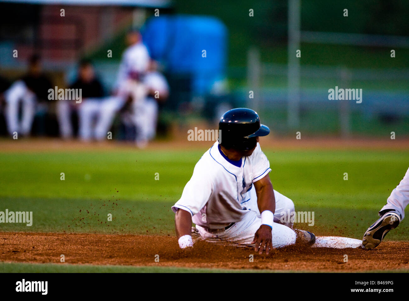 Baseball player sliding onto a base Stock Photo