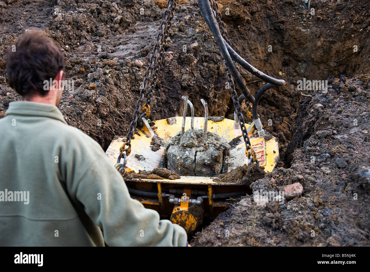 A pile crusher in place, slowly crushing the concrete before it can be removed. Stock Photo