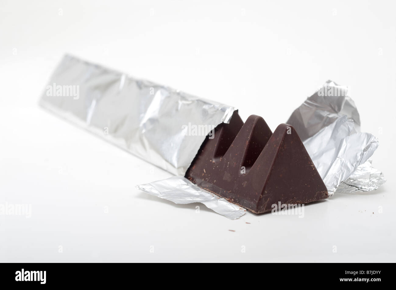 Triangular shaped dark chocolate bar in silver foil Stock Photo