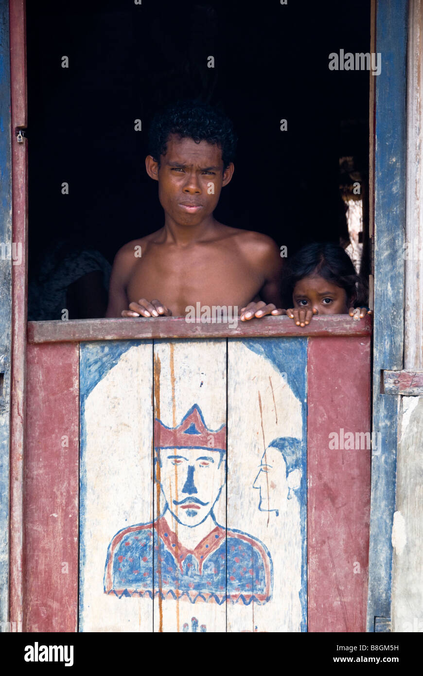 Man watching from his doorway in the traditional village of None, West Timor, Indonesia Stock Photo