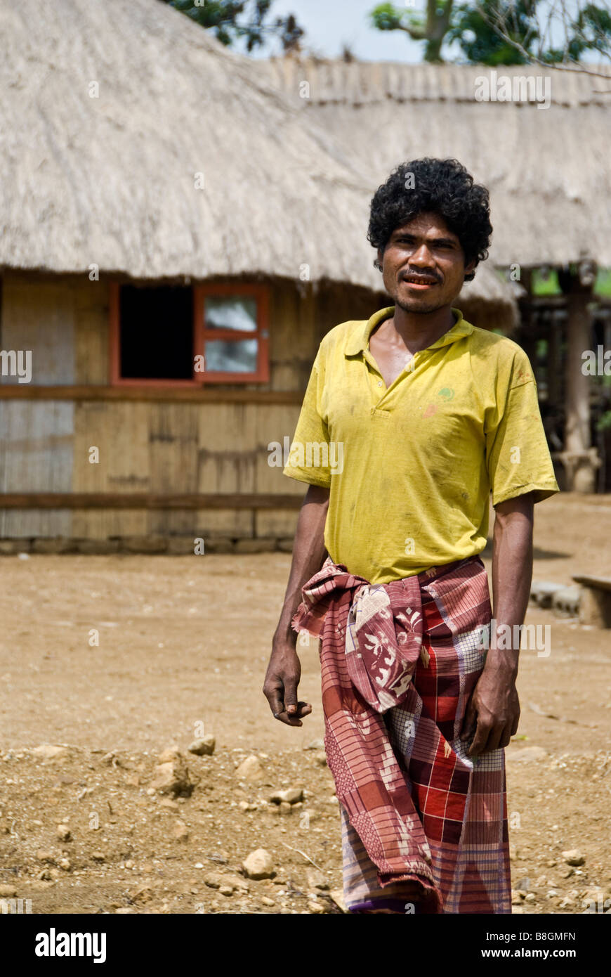 Man standing in front of his home in traditional Timorese village of None near Soe, Indonesia Stock Photo