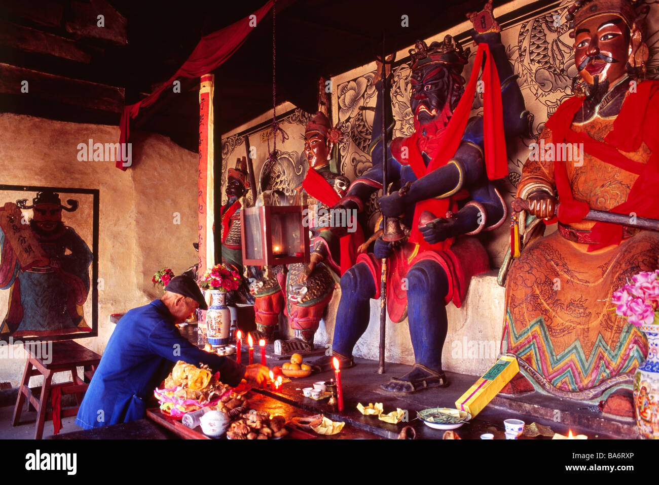 China, Yunnan province, Zhoucheng, the protector god of the village, devotee making offerings to the Benzhu Stock Photo