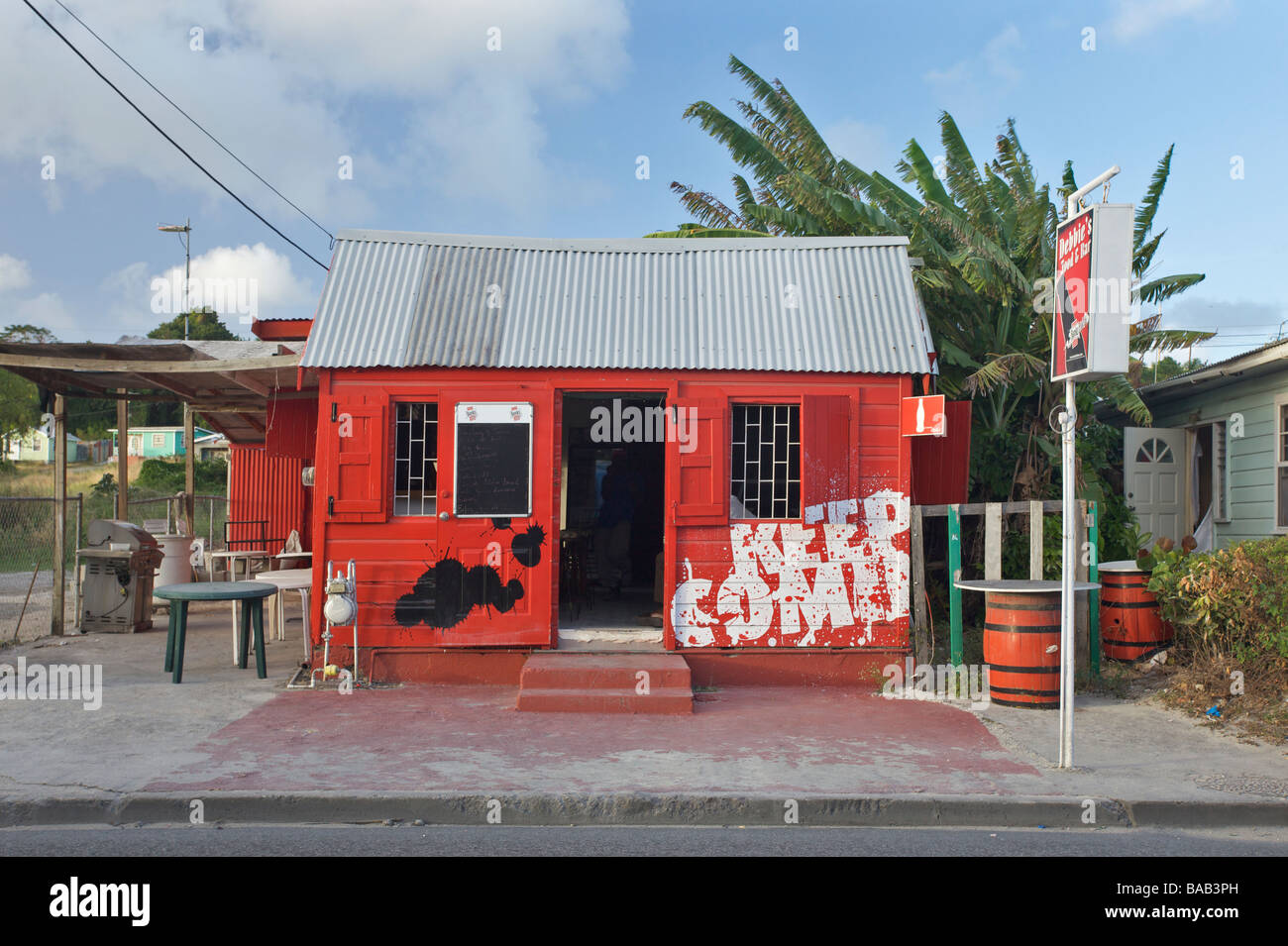 Brightly painted red 'Rum Shop' in Oistins fishing village, 'South Coast' of Barbados Stock Photo