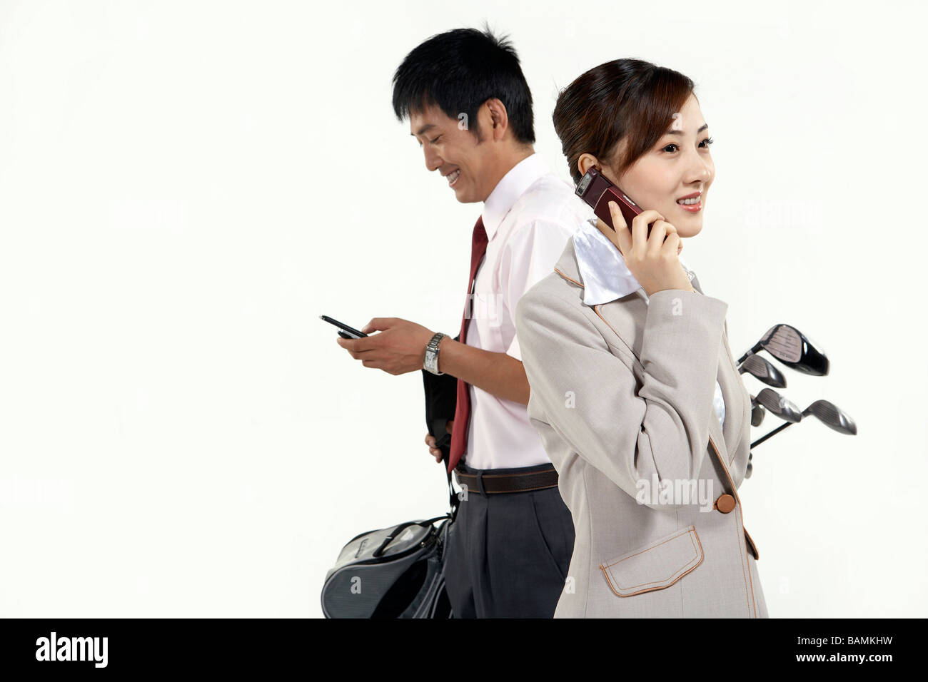 Businessman And Businesswoman With Golfclubs Stock Photo