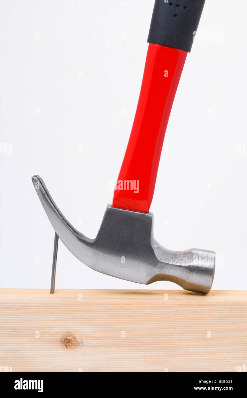 Using a claw hammer to remove a nail from timber Stock Photo