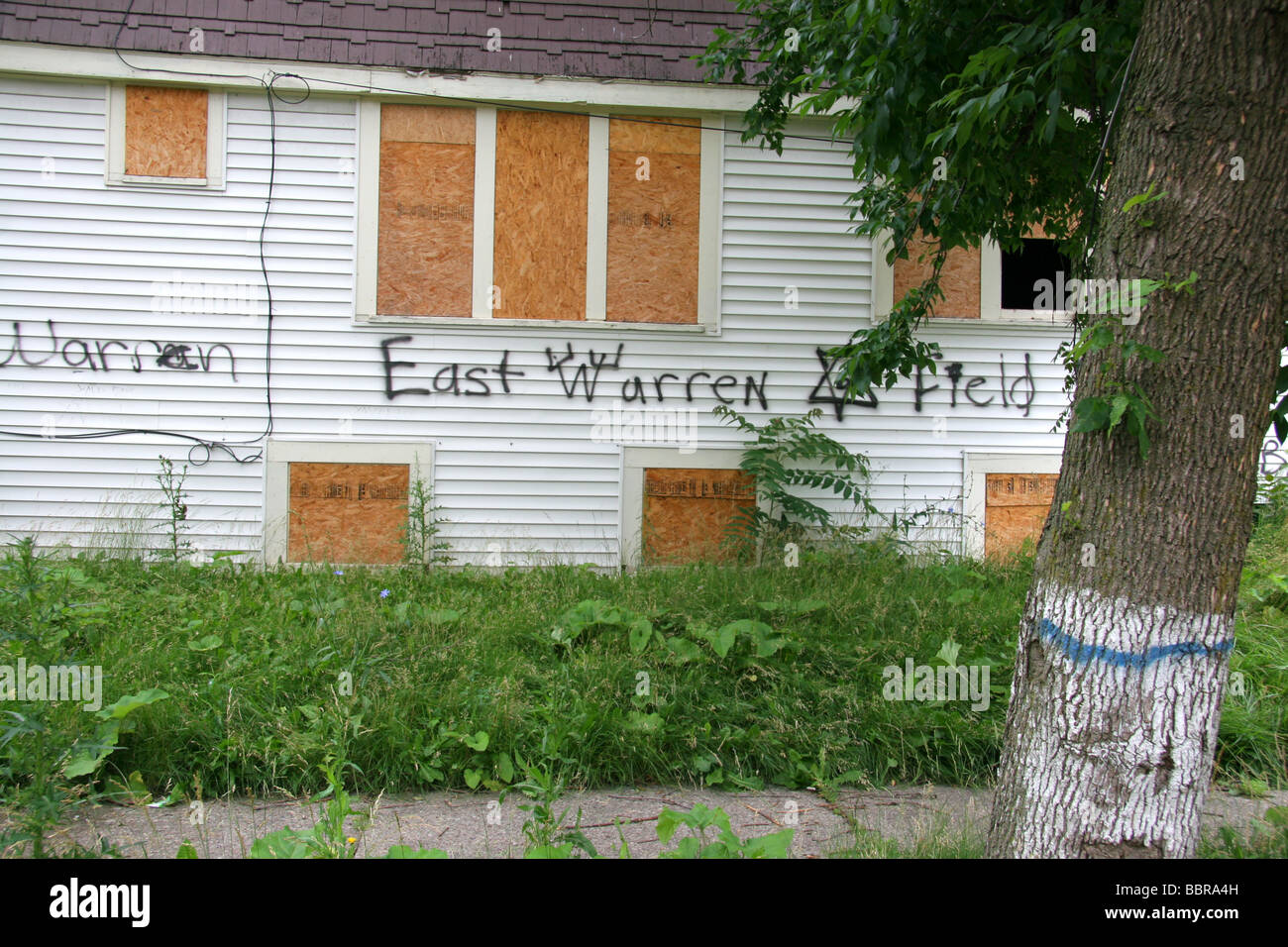 Boarded up house with gang markings and graffiti in Detroit Michigan USA Stock Photo