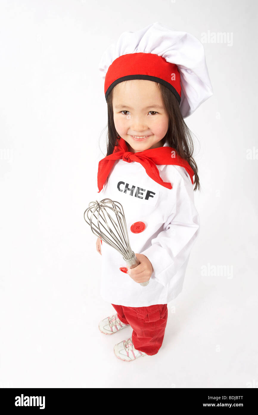 Little Girl Dressed Up as a Chef Holding a Whisk Stock Photo