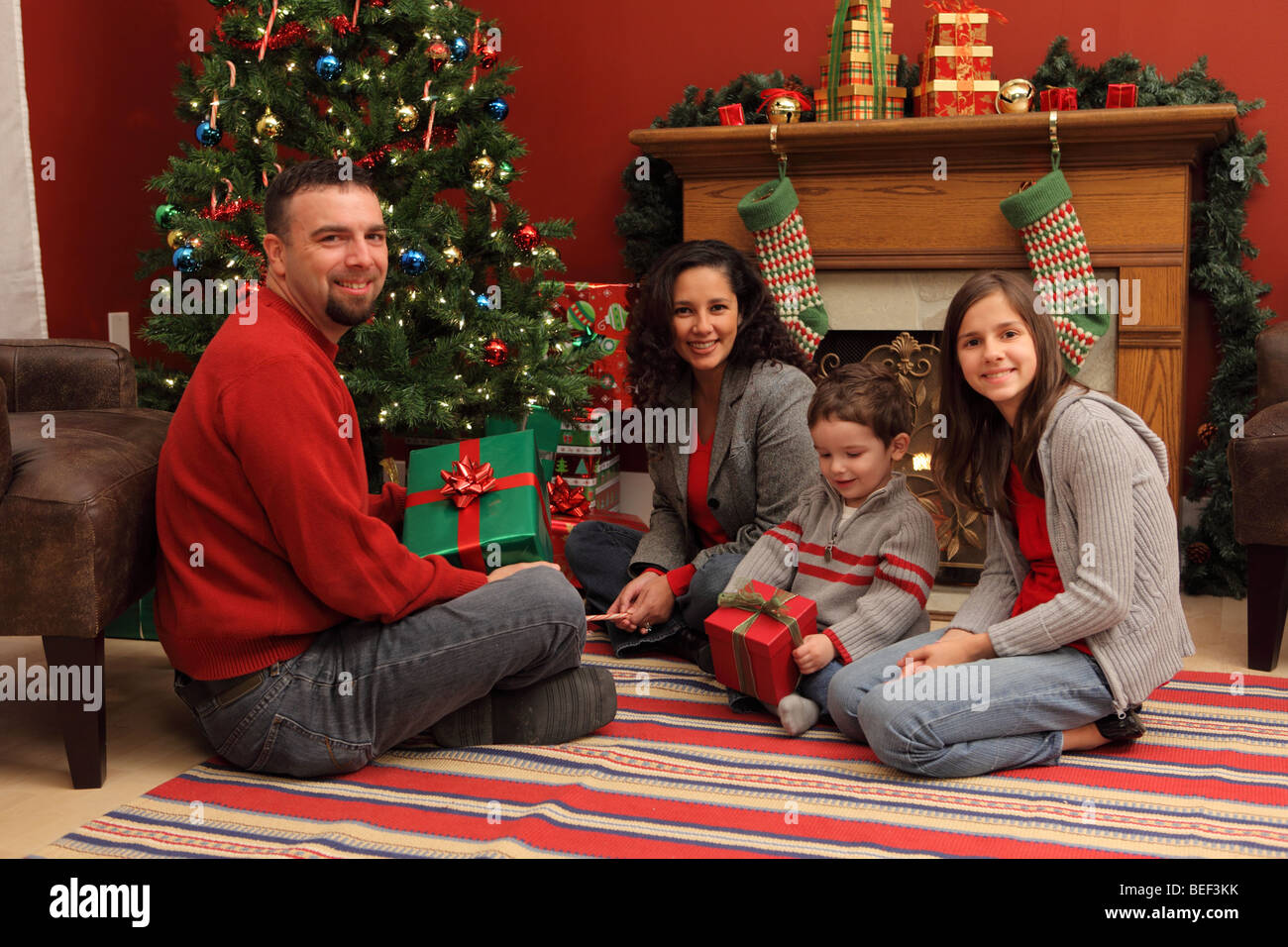 Family with gifts by Christmas tree Stock Photo