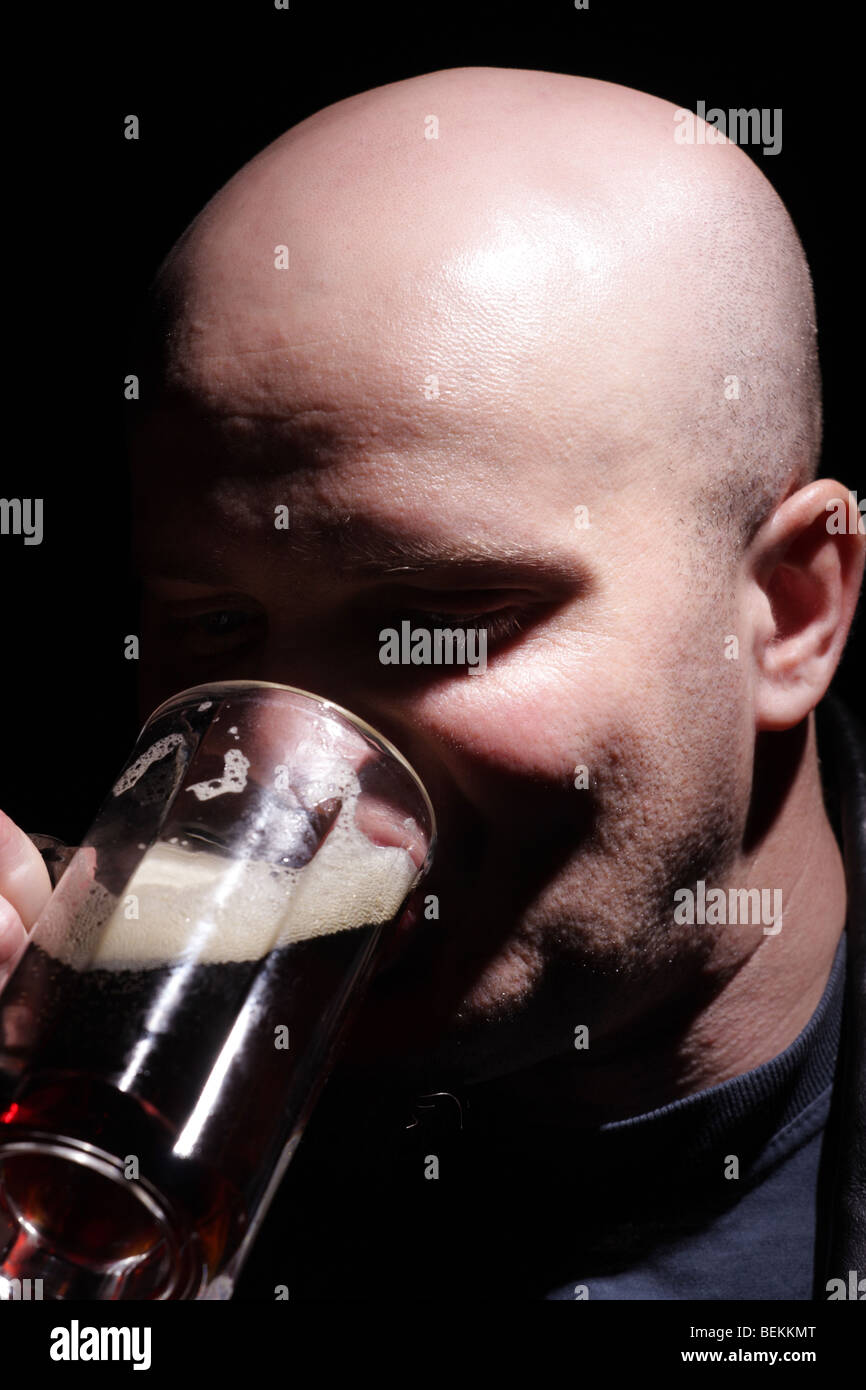 Bald man drinks beer. Stock Photo